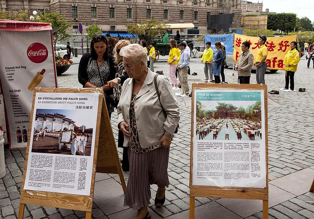 Ljudi se informiraju o Falun Gongu na Mynttorgetu.