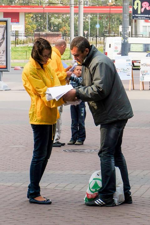 Prolaznik potpisuje peticiju podrške Falun Gongu.