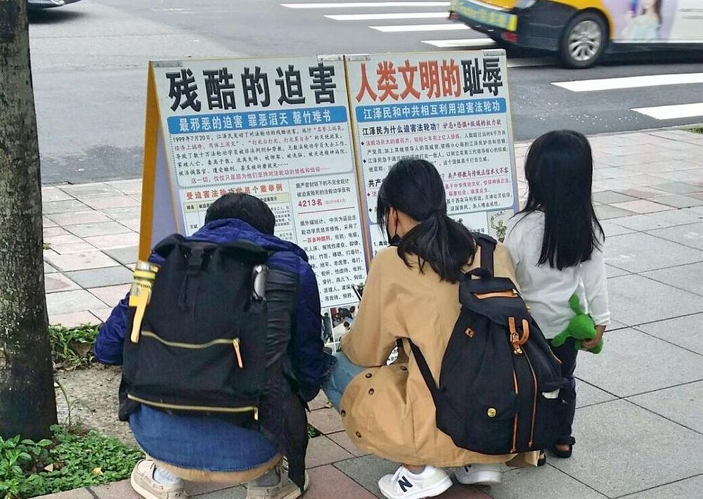 Kineski turisti čitaju o Falun Dafa ispred Memorijalne dvorane dr. Sun Yat-Sena.