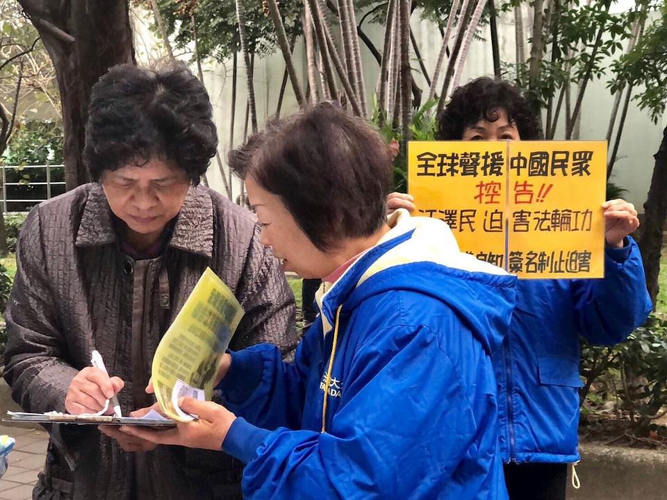 Prolaznici potpisuju peticiju, pozivajući kineske najviše sudove da procesuiraju više od 200.000 krivičnih prijava protiv Jiang Zemina i sprovedu politiku iz 2015. godine koja garantuje registraciju i obradu svih krivičnih i građanskih pritužbi 