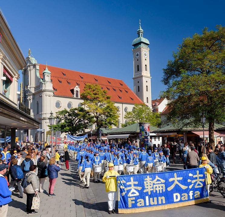 Falun Gong praktikanti marširaju kroz prometne ulice u centru Minhena u Njemačkoj.