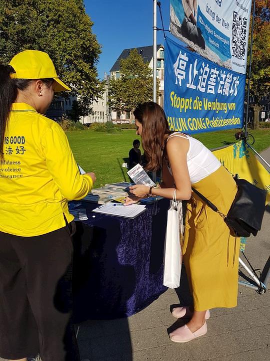 Prolaznik potpisuje peticiju za okončanje progona Falun Gonga u Kini 