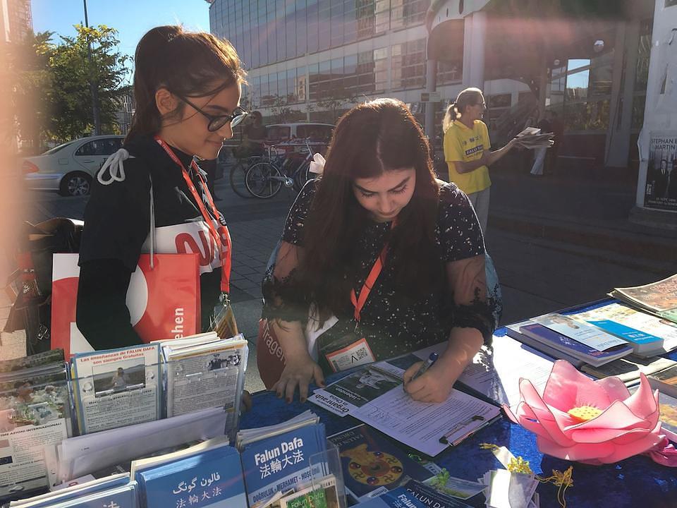Jasmina (lijevo) i Samija (desno) potpisuju peticiju za okončanje progona Falun Gonga u Kini
 