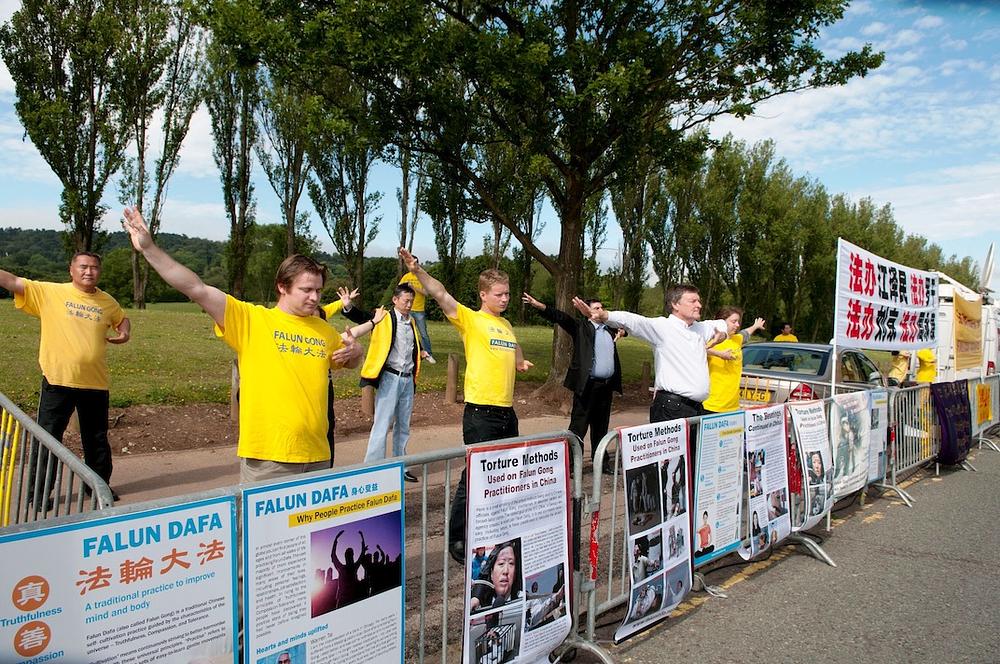 Policajka na dužnosti je pomno čitala poruke na posterima, dok su praktikanti izvodili Falun Gong vježbe