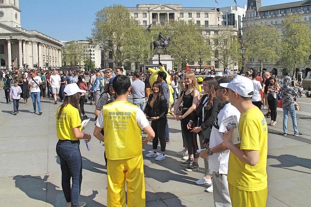 Turisti razgovaraju sa praktikantima i informišu se o Falun Gongu
