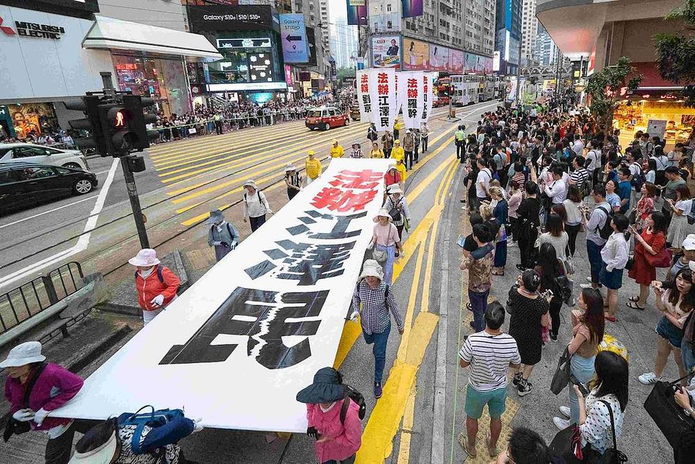 Transparenti na maršu na kojima piše „Dovedite Jianga pred lice pravde” 