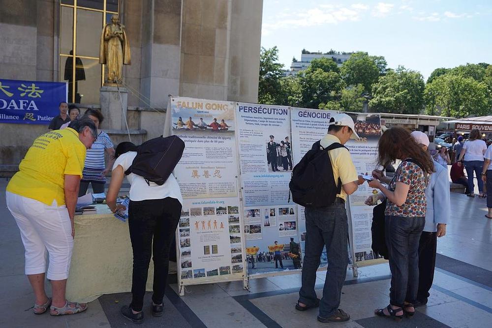 Praktikanti izlažu informacije i razgovaraju sa turistima na Trgu ljudskih prava, ispred Eiffelovog tornja
 