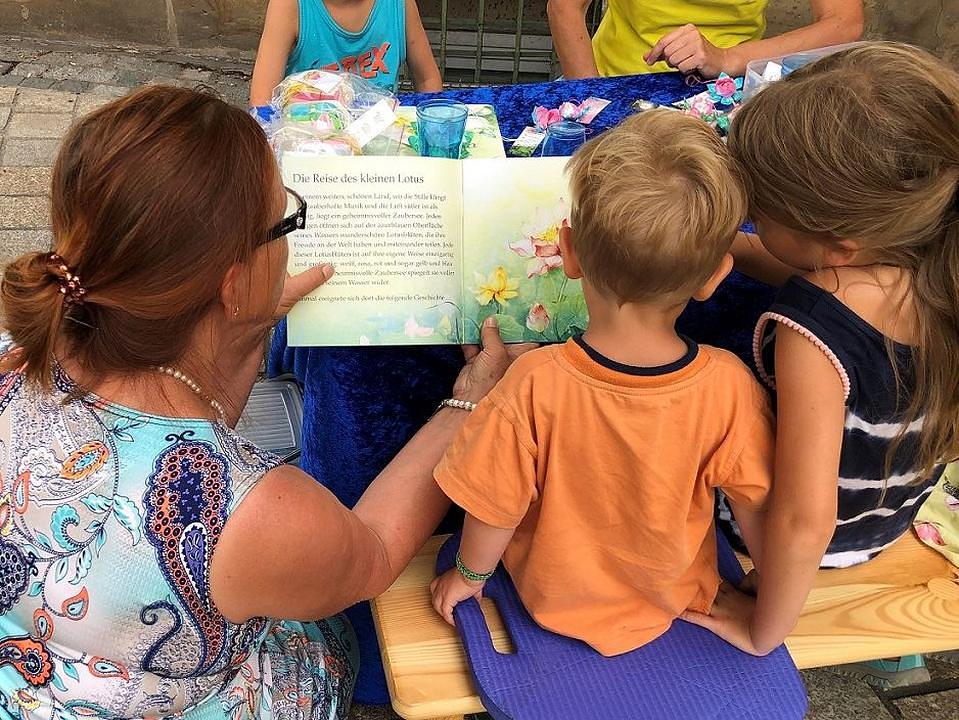 Praktikantica djeci čita „Priču o malom lotosovom cvijetu“.