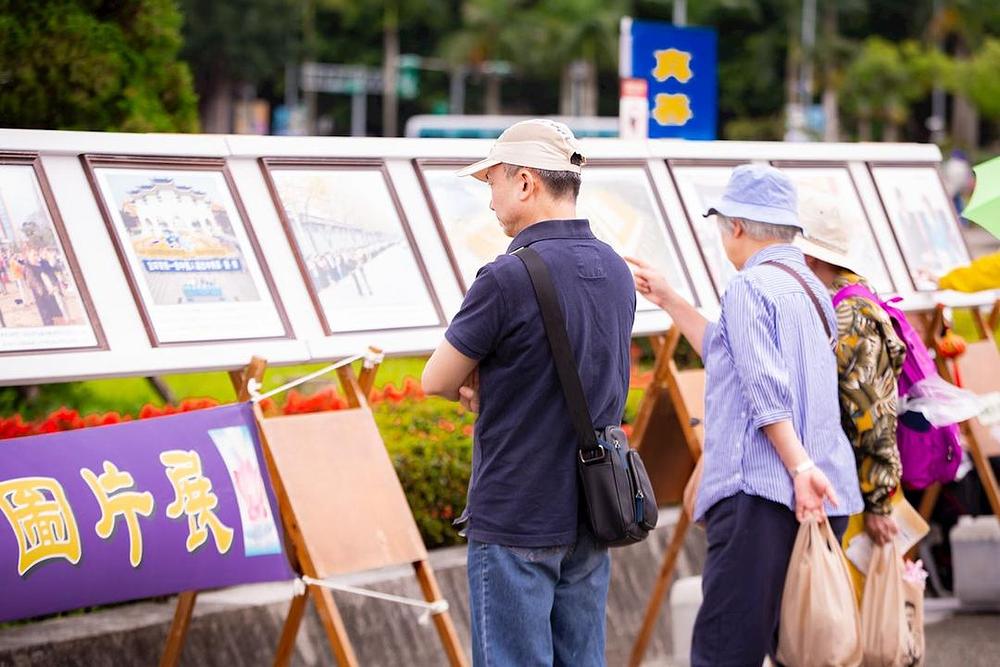 Turisti i prolaznici čitaju informacije o Falun Dafa, koga prakticira preko 100 miliona ljudi širom svijeta.