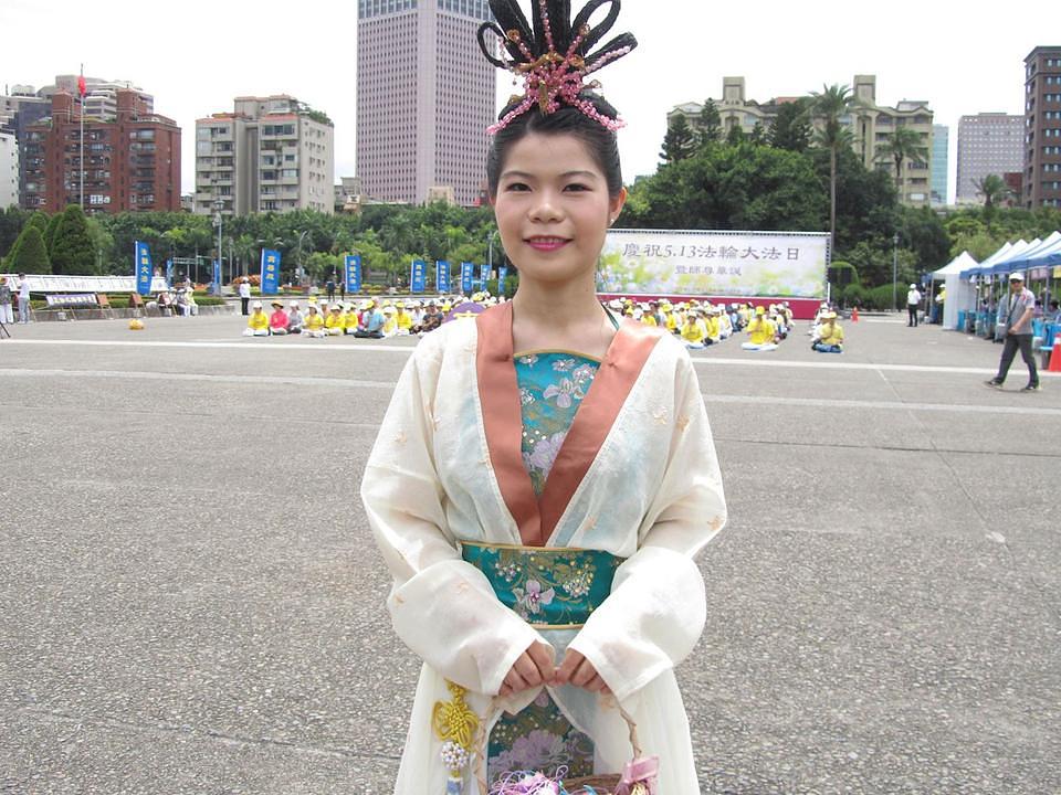 Gospođa Xu Ziling dijeli ukrase u obliku lotosovog cvijeta i s ljudima razgovara o Falun Dafa.