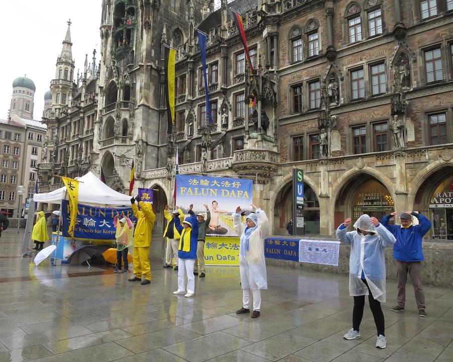 Demonstriranje izvođenja Falun Gong vježbi na kiši