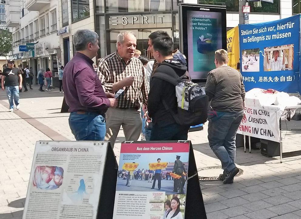 Razgovor sa prolaznicima o progonu Falun Dafa na informativnom danu u Hamburgu