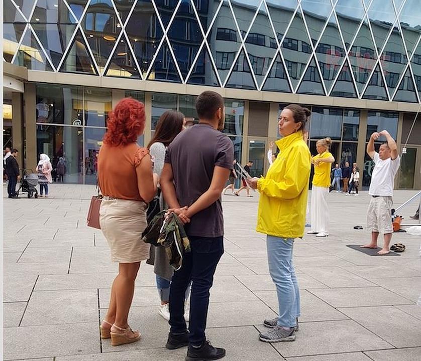 Prolaznici razgovaraju sa praktikantima na Falun Dafa štandu 31. avgusta 2019. godine, kako bi saznali više o ovoj praksi kultivacije.