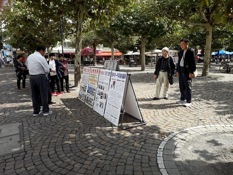 Kineski turisti čitaju plakate o suzbijanju Falun Gonga u Kini.