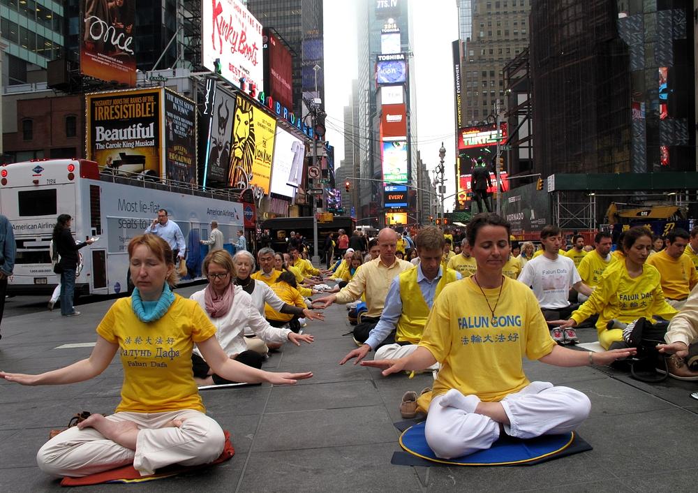 Gospođa Carole Caulier iz Švedske (desno u prvom redu) pridružila se grupnoj meditaciji na Times Square-u 15. maja 2014.