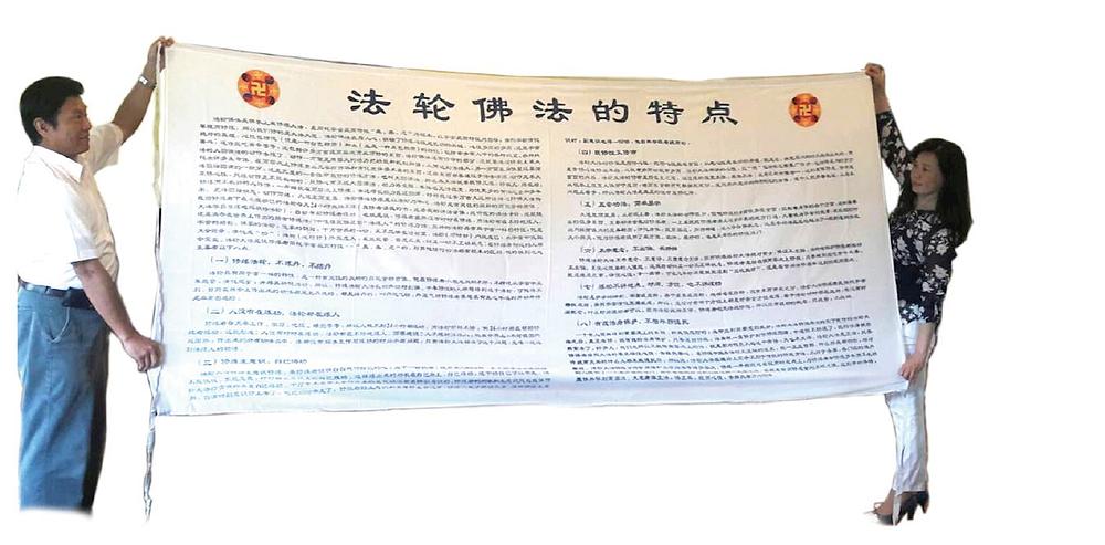 Zhenyu i njegova supruga pokazuju Falun Dafa transparent, koji je njihov ujak Putian donio iz Kine. (fotografija Broad Press) 