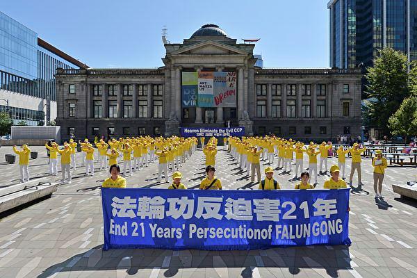 Praktikanti zajednički izvode Falun Gong vježbe na platou ispred umjetničke galerije u Vancouveru, 12. jula 2020. godine