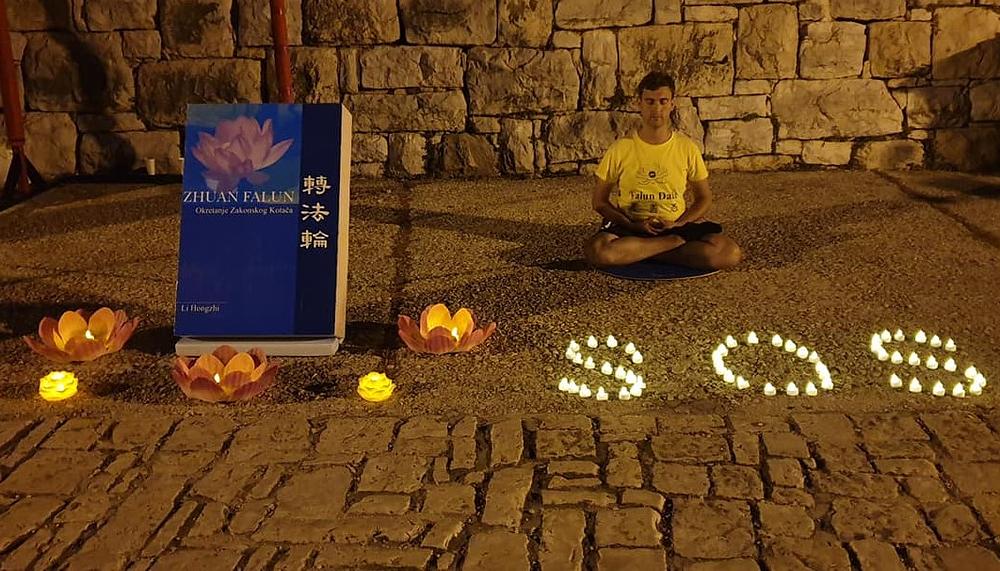 Postav Falun Dafa štanda za bdijenje uz svijeće