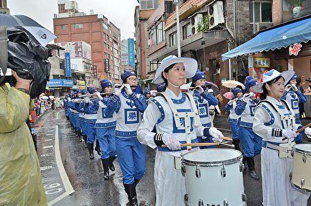 Tian Guo Mmarching Bband koji sačinjavaju praktikanti Falun Gonga, je nastupio na paradi na Tamsui festivalu umjetnosti prirodnog okruženja uprkos pljusku.