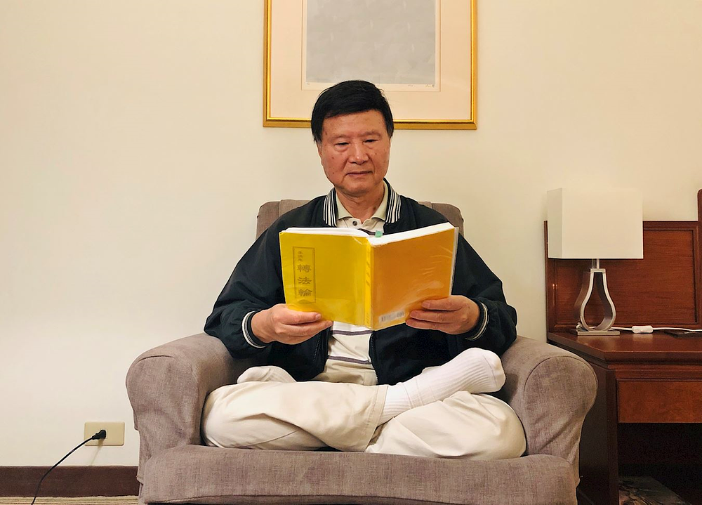 Wenhai čita Falun Dafa knjigu.