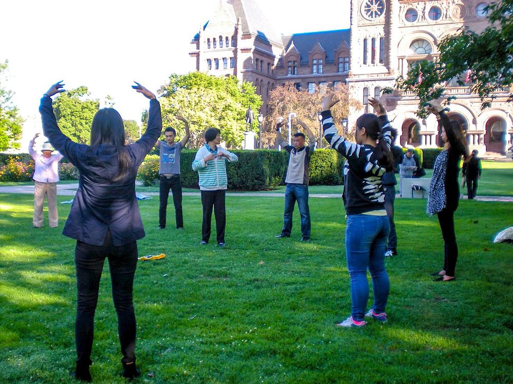 Jinju podučava turiste iz Кine pet Falun Gong vežbi u Queens Parku u Torontu