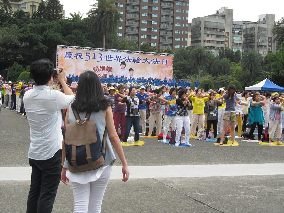 Turisti fotografiraju izvođenje  Falun Dafa vježbi