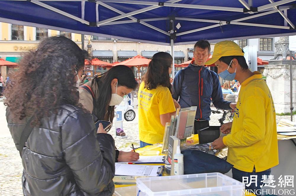 Lokalni stanovnici potpisuju peticiju za okončanje progona Falun Dafa.
 