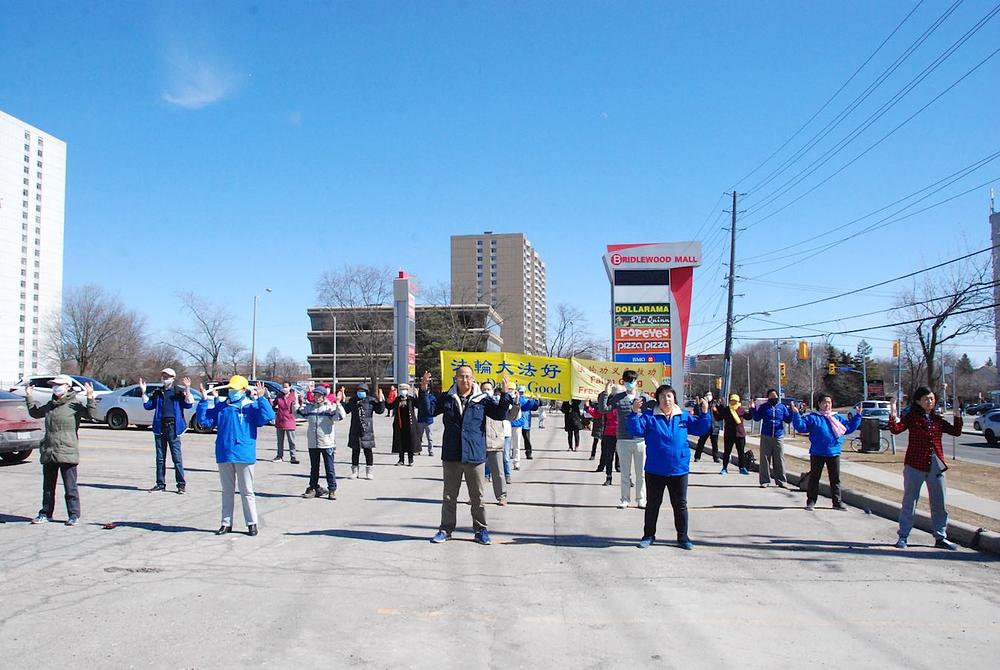 Praktikanti Falun Gonga demonstriraju vježbe pred Warden & Finch Real Estate u Scarboroughu u Torontu.