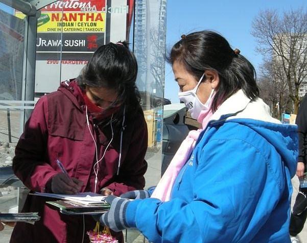 Prolaznici potpisuju peticiju kojom podržavaju napore praktikanata da okončaju progon u Kini koji traje već 21 godinu.