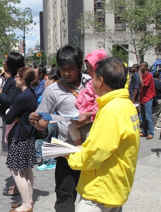 Prolaznik čita Falun Dafa informativni letak.