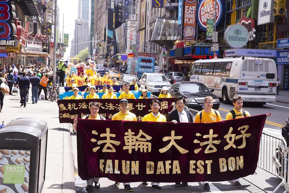 Transparent sa čela povorke na kom je napisano: Falun Dafa je dobar.