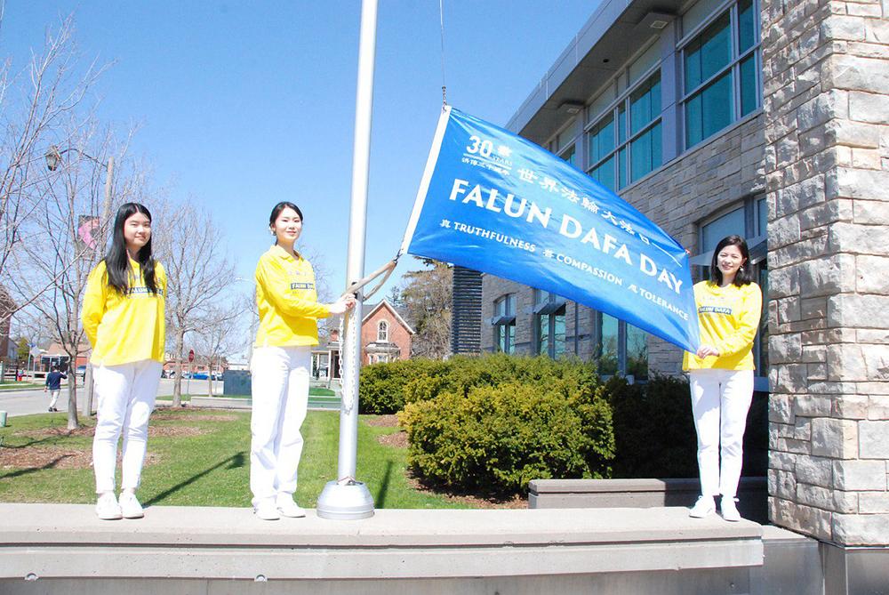 Na ceremoniji Falun Dafa praktikanti podižu zastavu