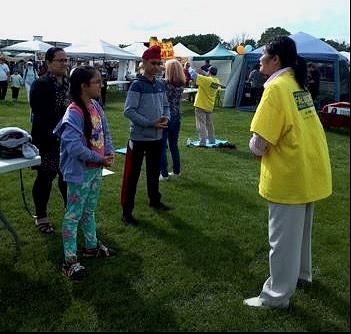  Porodica iz Indije uči Falun Dafa vježbe na festivalu.