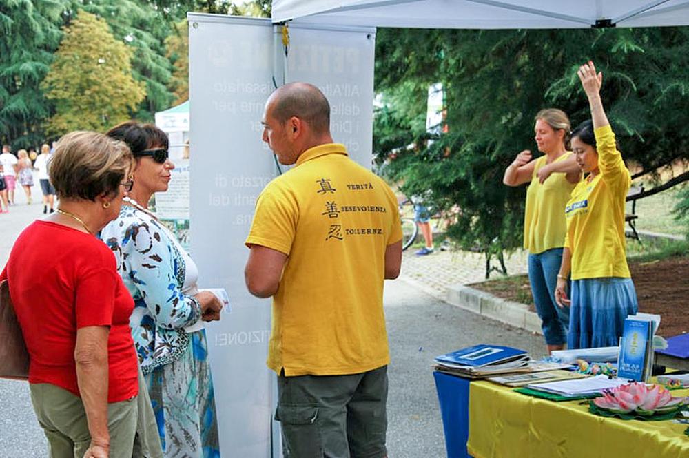 Praktikant razgovara s posjetiteljima o Falun Gongu i o progonu u Kini