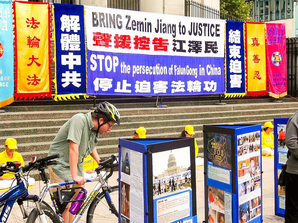 Prolaznici se informiraju o progonu Falun Gonga i potpisuju peticiju u ime podrške svim naporima da se Jiang dovede pred lice pravde