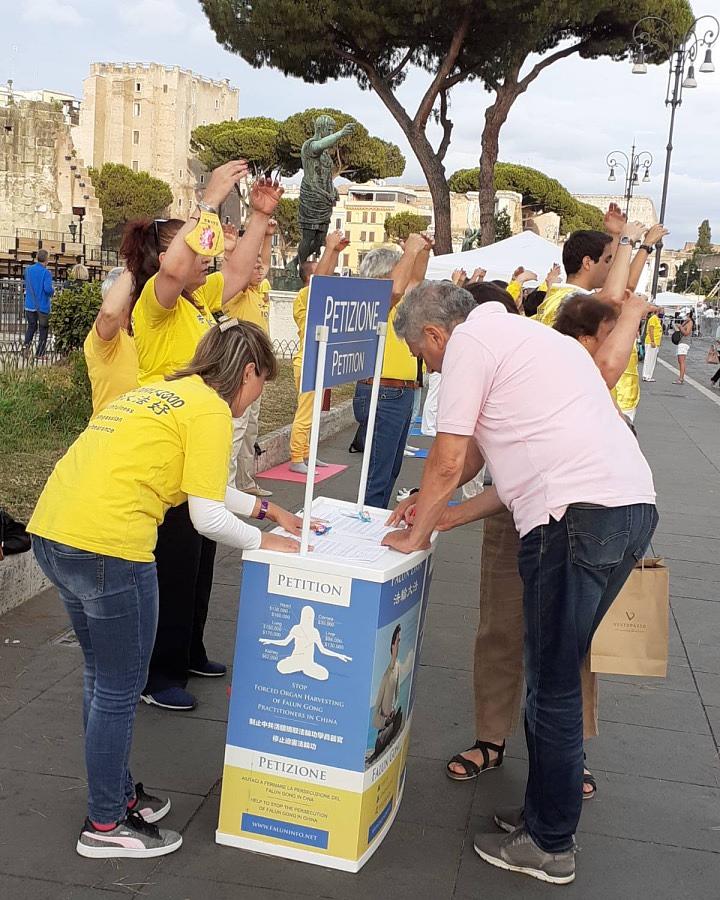 Prolaznik u Rimu potpisuje peticiju tokom informativnih aktivnosti 