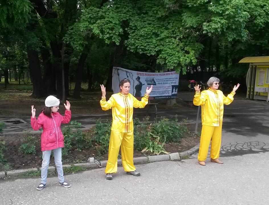 Praktikanti demonstriraju vježbe Falun Gonga ispred kineske ambasade 10. maja 2015. godine. Djevojčica im se pridružila da nauči vježbe.