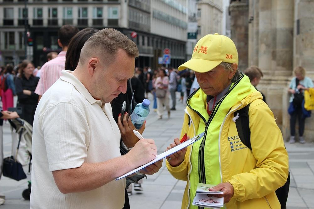 Mnogi ljudi su, 5. avgusta 2023., zastali da pročitaju informativne table i potpišu peticiju za okončanje progona tokom događaja na trgu Herbert-von-Karajan-Platz