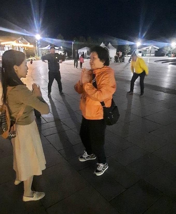  Posjetitelji se i dalje raspituju o Falun Dafa, iako je padao mrak.