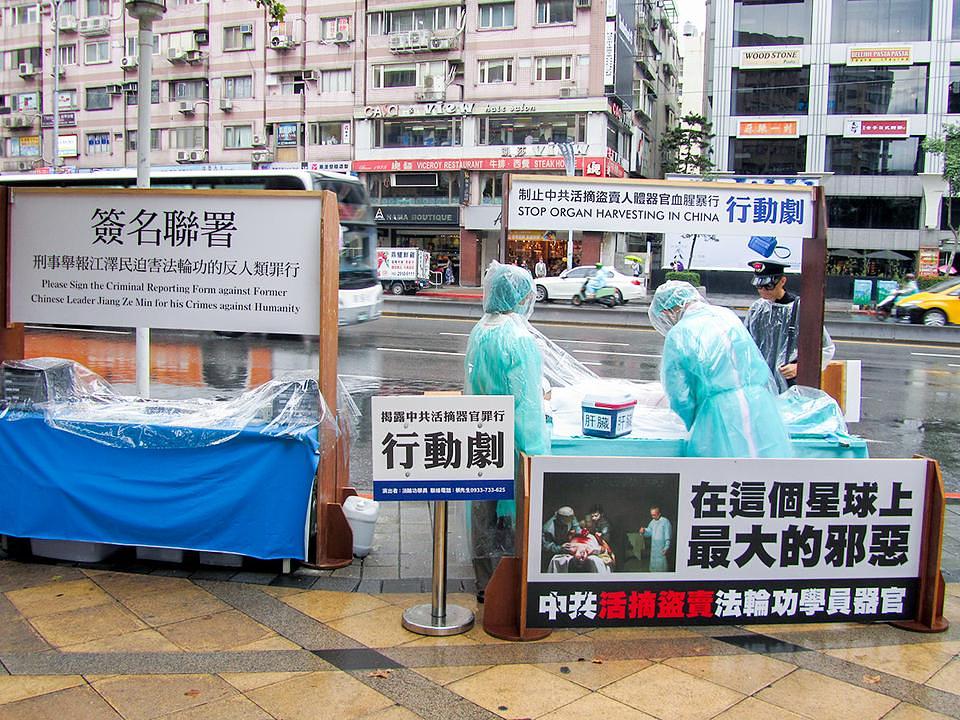 Praktikanti Falun Gonga predstavljaju prizor rekonstrukcije žetve organa koji se uzimaju od  živih Falun Gong praktikanata, a koju je organizovala Kineska Komunistička Partija (KKP) i prikupljaju potpise za okončanje ovih zvjerstava.