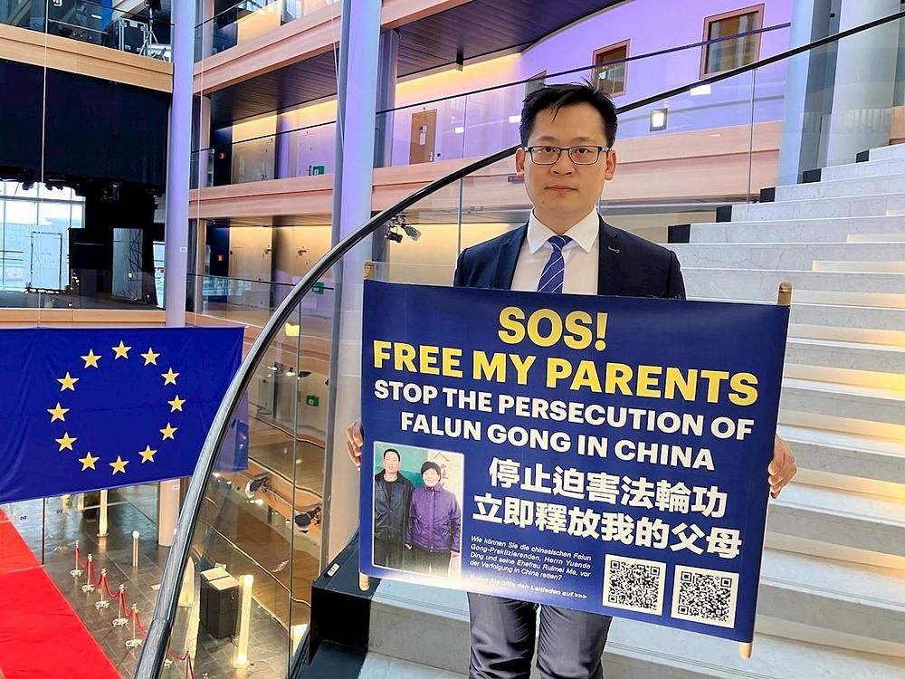  Praktikant Ding Lebin poziva na oslobađanje svojih roditelja tijekom događaja ispred Europskog parlamenta.
