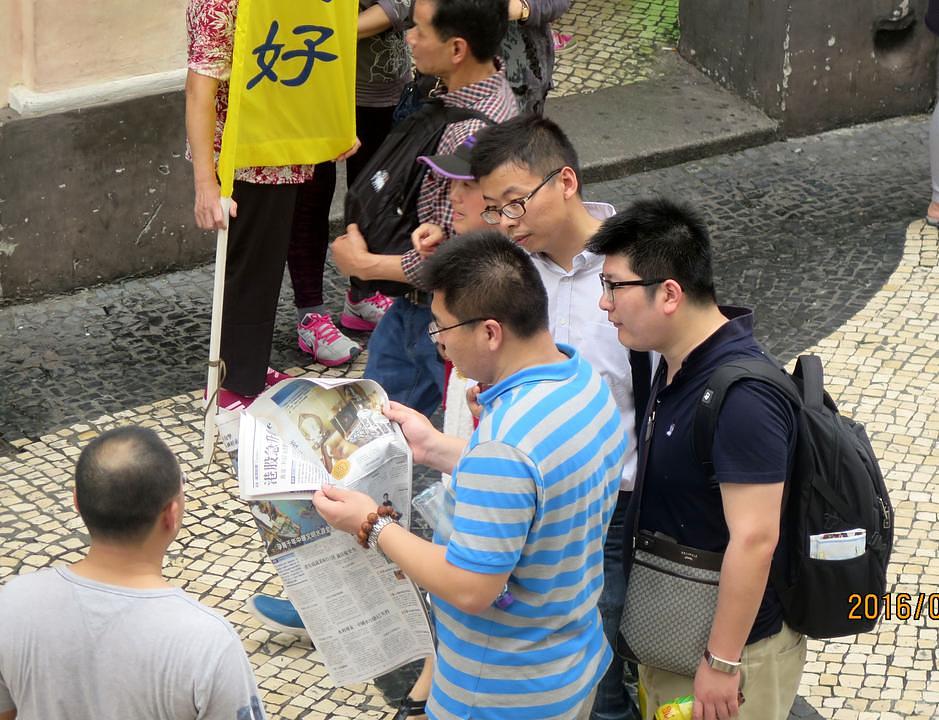 Kineski turisti čitaju Falun Gong materijale