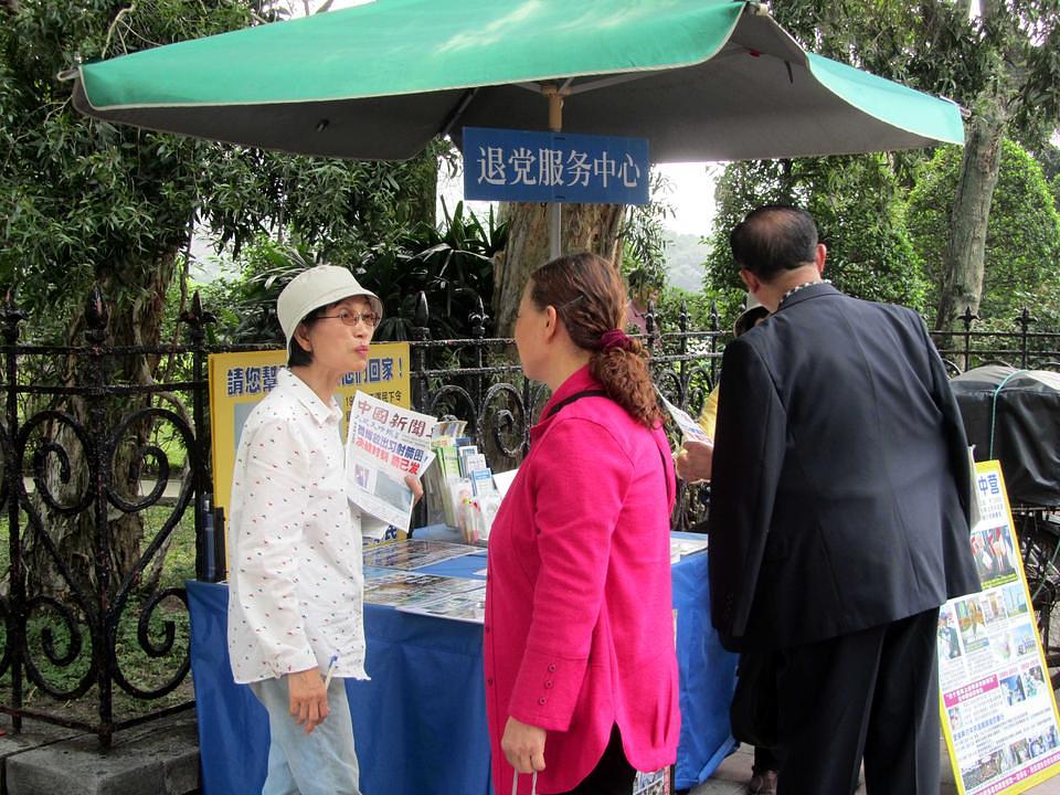 Praktikantica Falun Gonga (u bijeloj odjeći) razgovara sa kineskim turistom o istupanju iz Kineske komunističke partije.