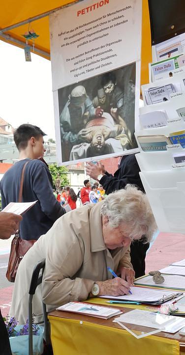 Prolaznici na stanici u Bernu potpisuju peticiju kojom se osuđuje progon Falun Gonga 