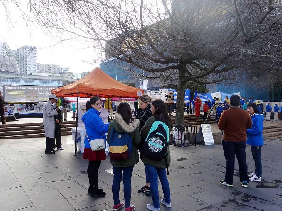 Prolaznici razgovaraju s praktikantima Falun Gonga 