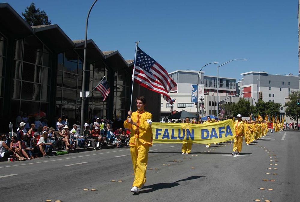 Učitelj umjetnosti Perry Uzunoglu je na paradi nosio zastavu. „Falun Gong me je naučio da prvo vodim računa od drugim osobama i da unutar sebe tražim probleme kada se nađem u konfliktu sa drugim osobama“, kazao je.