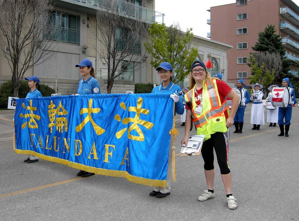 Brittney Mylko (desno), organizatorica parade u Port Creditu, kazala je da su načela Istinitosti-Dobrodušnosti-Tolerancije ono za čime ona teži. Vjeruje da ta načela dolaze sa višeg nivoa. Kazala je i da želi isprobati Falun Gong meditaciju. „Progon u Kini je užasan. Kina treba naučiti od Kanade i SAD kako da prihvati grupe sa drugačijim vjerovanjima. Progon treba prestati!“ 