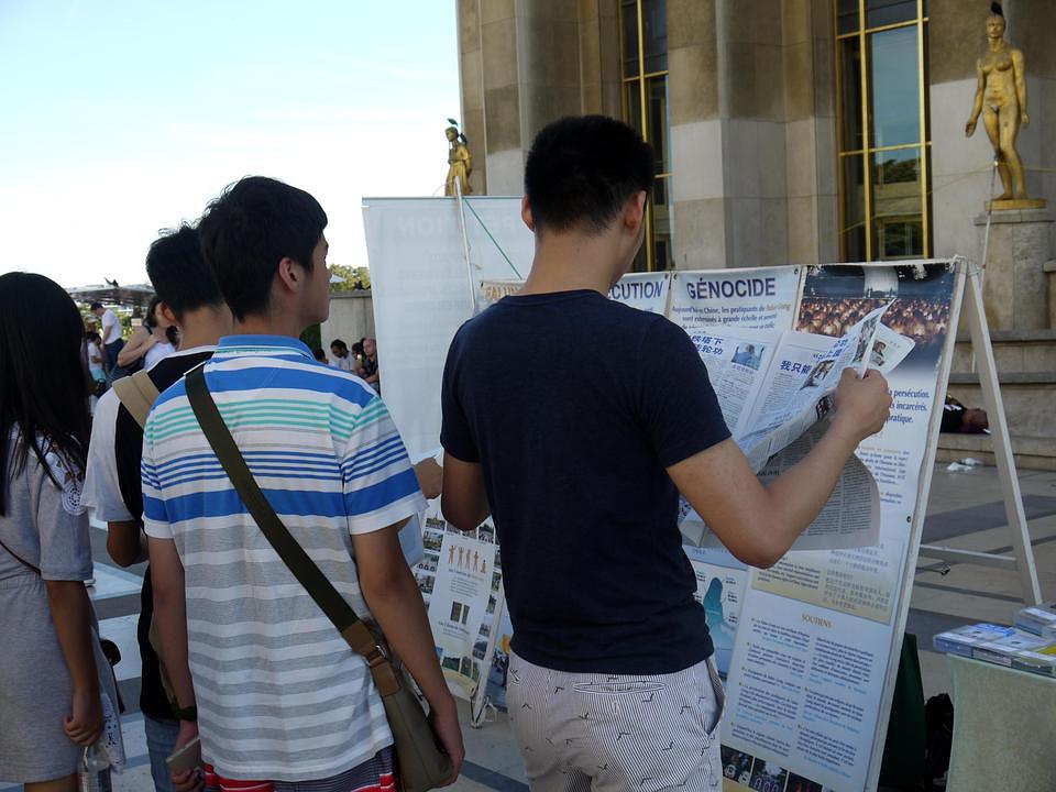 Prolaznici čitaju o Falun Gongu.