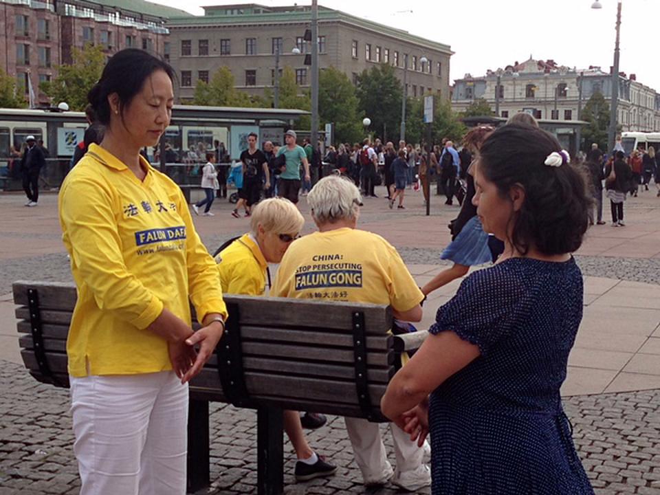 Turisti čitaju o Falun Gongu i uče vježbe na Festivalu kultura u Geteborgu.
