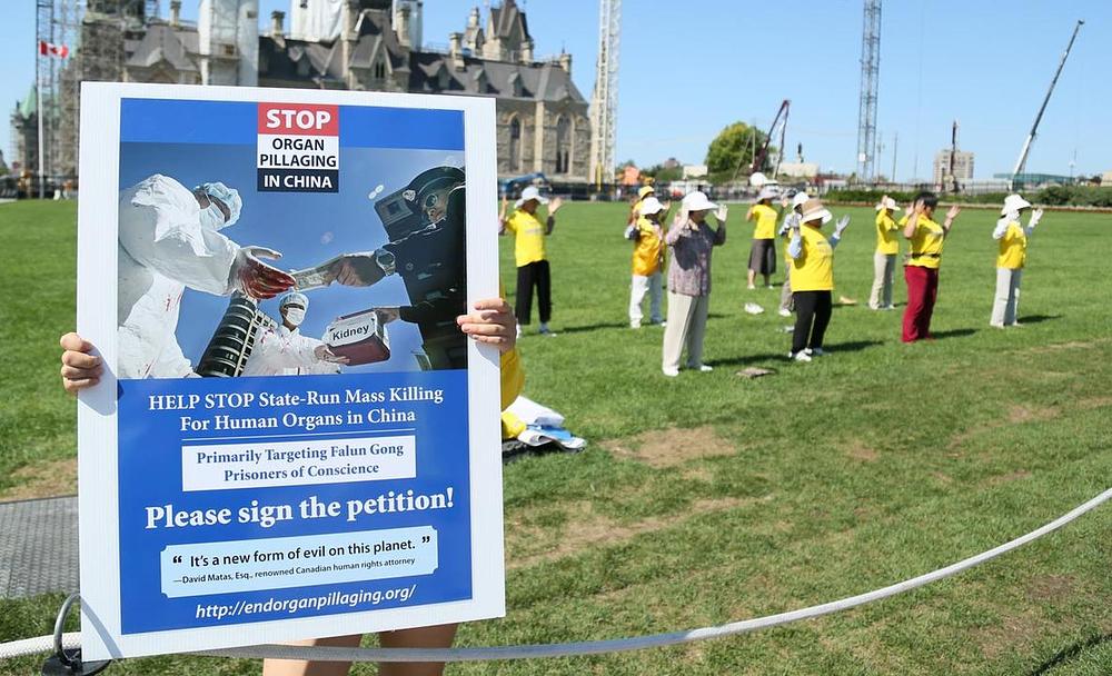 Demonstracije Falun Gong praktikanta ispred Parliament Hilla u Otavi 26. avgusta 2016. godine pozivaju na pomoć u zaustavljanju progona. 